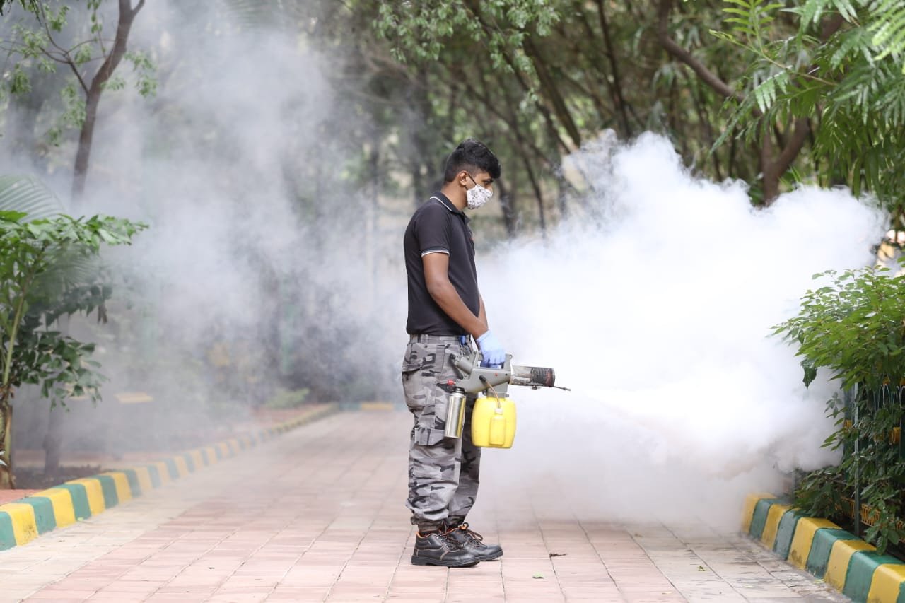Certified technician performing an outdoor pest treatment
